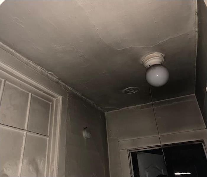 soot damage covering a ceiling and light fixture